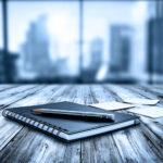 Notebook organizer on wooden desk with pencil depicts advisory services